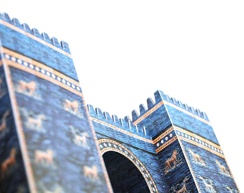 Closeup of the scale model of the Great Gate of Ishtar featuring two towers and the entrance arch between them. The model is made out of full-colour printed paper parts to replicate blue glazed brick walls decorated with golden stripes and animals.