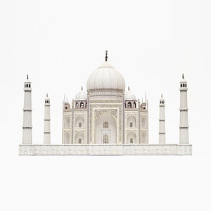 May include: A white model of the Taj Mahal, a famous mausoleum. The model features the central dome, minarets, and intricate architectural details. The background is plain white.