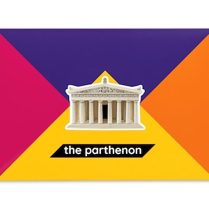 Product packaging for the Parthenon paper model kit. A rectangular bright coloured cardstock envelope features four large triangles in yellow, magenta, purple and orange with an image of a finished model at the centre and the product title below.