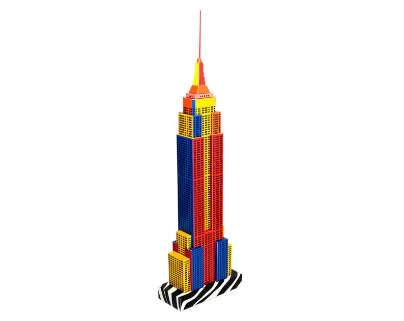 The skyscraper replica features Empire State building of New York. The model features a black and white base, along with rows of vertical red, yellow, and blue strips layered along its facades.
