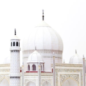 Closeup the 3D paper model of Taj Mahal shows one of its minarets with the central dome and kiosk domes in the background.