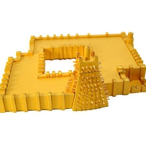 Assembled 3d scale model of the Sankoré Mosque, one of three ancient learning centers located in Timbuktu, Mali. The model is made out of golden paper parts, it features the pyramidal mihrab and inner courtyard.