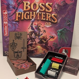 Könnte beinhalten: Ein Brettspielkasten mit dem Titel "BOSS FIGHTERS QR" mit Fantasy-Artwork. Das Spiel enthält verschiedene Spielsteine, darunter Spielmarken, Würfel und Miniaturfiguren. Die Box ist lila und rot, mit dem Spieltitel in Gold.