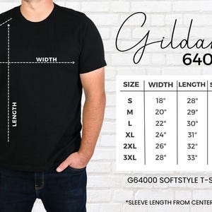 K&ouml;nnte beinhalten: Ein schwarzes Gildan 64000 Softstyle T-Shirt mit einer Gr&ouml;&szlig;entabelle, die Ma&szlig;e in Zentimetern anzeigt. Die Tabelle umfasst die Gr&ouml;&szlig;en S bis 3XL, mit einer Breite von 45.7cm bis 71.1cm, einer L&auml;nge von 71.1cm bis 83.8cm und einer &Auml;rmell&auml;nge von 20.9cm bis 24.1cm.