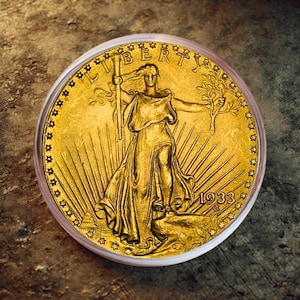 Könnte beinhalten: Eine goldene Münze mit einer Frau, die eine Fackel und einen Zweig hält, mit der Aufschrift "LIBERTY" darüber. Die Münze, datiert 1933, befindet sich in einer transparenten Schutzhülle. Das Design ist sehr detailliert und komplex.