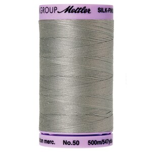 May include: A spool of gray Mettler Silk-Finish cotton thread with the label "GROUP Mettler SILK-FINISH cotton merc. No.50 500m/547yds"