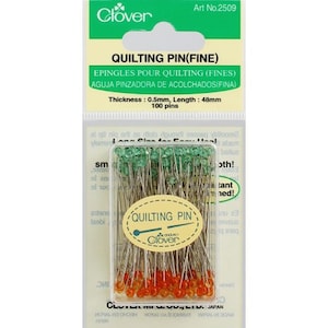 May include: A package of 100 fine quilting pins with green and orange heads. The package is labeled "Clover Quilting Pin (Fine)" and includes the text "Thickness: 0.5mm, Length: 48mm".