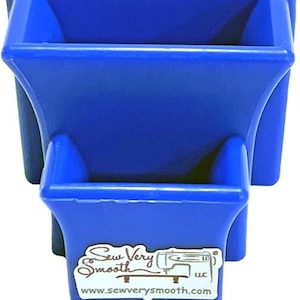 May include: A stackable, royal blue plastic organizer with two compartments. The bottom compartment has a sticker with the text "Sew Very Smooth" and a website address. The organizer is designed for sewing supplies.