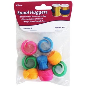 May include: A package of eight colorful spool huggers designed to keep thread from unraveling. The huggers are in various colors, including green, blue, pink, orange, and purple. The package includes the text "Spool Huggers" and "Contents: 8".