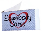 Tag It Ons -  Somebody Cares - 12 tags per packet. 1-1/8" x 5/8" - Little tags that can be attached to your quilts or crafts