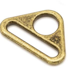 May include: A gold-toned triangle-shaped metal D-ring with a small round hole and a stamped logo that reads "B2A".