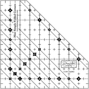 May include: A black and white ruler with markings for sewing and quilting. The ruler is labeled "Mini Simple Folded Corners" and has numbers 1 through 4 on it. The ruler is designed to help quilters create folded corners.