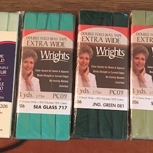 May include: Six spools of double fold bias tape in various shades of green. The tape is extra wide and is labeled "Wrights" with the product name and color code. The tape is 3 yards long.