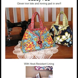 May include: A colorful fabric caddy with a heat-resistant lining. The caddy is shaped like a tote bag and has a button closure. The text "Sisters' Common Thread" and "Caddy Pad" is visible in the image. The text "Clever iron tote and ironing pad in one!!" is also visible in the image.
