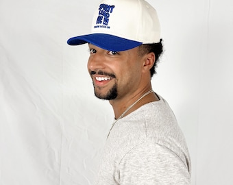 May include: A white and blue baseball cap with the text "SPIRIT LEAD ME!!" in blue embroidered lettering. The cap has a blue brim.