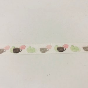 May include: Decorative washi tape featuring a repeating pattern of watercolor-style coffee cups, green apples, and pink floral shapes. The coffee cups have the word "cafe" printed on them. The tape is on a white background.