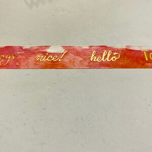 May include: Decorative washi tape with a watercolor-style background in shades of red and orange. Gold lettering spells out "good things", "nice!", "hello", and "TODAY". The tape is ideal for scrapbooking and crafts.