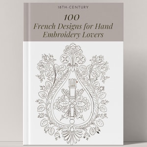 Pode incluir: Capa de livro com o título "100 French Designs for Hand Embroidery Lovers" e uma ilustração de um desenho floral com uma flecha e um aljava no centro.