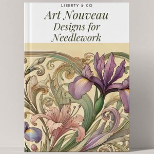 Könnte beinhalten: Buchumschlag mit einer Illustration von lila und rosa Blüten mit grünen Blättern und filigranen goldenen Schnörkeln auf cremefarbenem Hintergrund. Der Titel des Buches lautet "Art Nouveau Designs for Needlework" mit dem Untertitel "LIBERTY & CO."