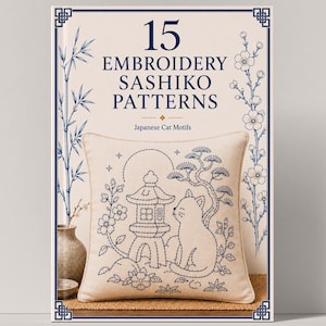 May include: A book cover titled 15 EMBROIDERY SASHIKO PATTERNS Japanese Cat Motifs. The cover features a beige cushion with a blue stitched design of a cat, a stone lantern, and a tree, framed by blue bamboo and floral illustrations on a cream background.