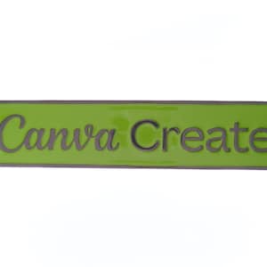 May include: A rectangular, lime green pin with the words "Canva Create" in a dark gray, cursive font. The pin has a dark gray border and is set against a white background.
