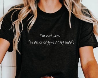 May include: A black t-shirt with the text "I'm not lazy. I'm on energy-saving mode" printed in white.