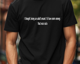 May include: A black t-shirt with white text that reads "I thought being an adult meant I'd have more money. That was cute."