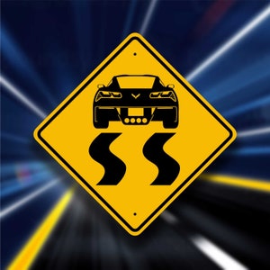May include: A yellow diamond-shaped road sign with black text and a black silhouette of a sports car. The sign reads "SS" and depicts a car driving on a winding road.