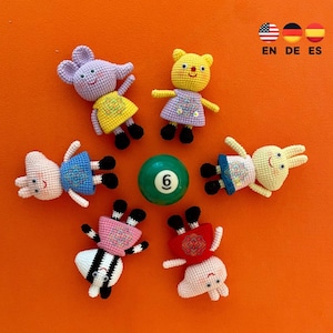May include: A selection of handmade crochet animal dolls, including a mouse, bear, pig, and rabbit, each wearing a dress. A green billiard ball with the number 6 is in the center. The background is orange, and the text "EN DE ES" is in the top right corner.