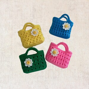 May include: Four small crocheted bags with daisy flower embellishments. The bags are in yellow, blue, pink, and green.