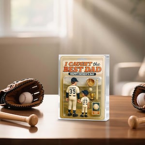 May include: A baseball-themed Father's Day gift set featuring two figurines, a baseball glove, a baseball, and a trophy. The packaging reads "I CAUGHT the BEST DAD" and "HAPPY FATHER'S DAY". The figurines are wearing baseball uniforms.