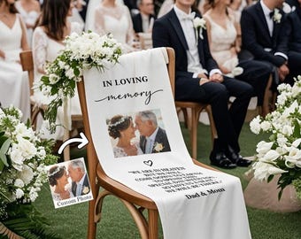 May include: A white fabric chair sash with the words "IN LOVING memory" and a photo of a couple. Below the photo is a quote and the words "Dad & Mom". The sash is draped over a wooden chair at a wedding.