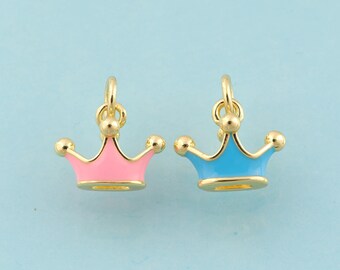 May include: Two gold-colored crown charms, one with pink enamel and one with blue enamel.