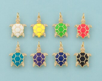 May include: Eight gold-colored turtle pendants with colorful enamel shells. The turtles are in white, yellow, green, red, teal, purple, navy blue, and black. Each pendant has a loop for hanging and is set against a light blue background.