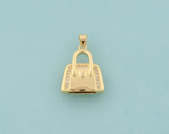 May include: A gold-tone handbag pendant with clear crystal accents. The pendant features a heart-shaped detail on the front.
