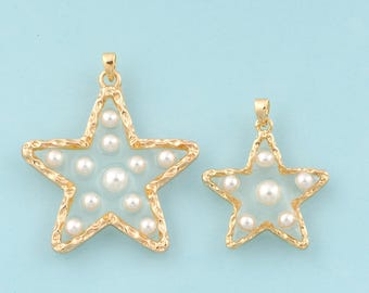 Può includere: Due ciondoli a forma di stella dorati con accenti di perle bianche. Il ciondolo più grande è largo circa 5 cm e il ciondolo più piccolo è largo circa 2,5 cm.