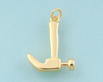 May include: A gold-colored hammer charm with a loop at the top for attaching to a necklace or bracelet. The hammer has a curved claw and a rounded head. The charm is set against a light blue background.