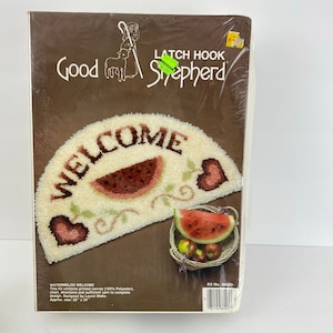 May include: A latch hook kit for a welcome mat with a watermelon and hearts design. The kit includes printed canvas, yarn, and instructions. The finished mat is approximately 20 inches by 34 inches.