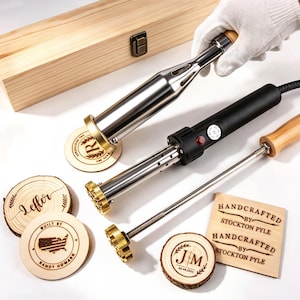 May include: A branding iron set featuring two metal heating tools with wooden handles and interchangeable brass heads. The set includes several circular and square wooden pieces branded with custom text and designs like R, Leffor, JM, and Stockton Pyle.