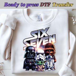 May include: White sweatshirt featuring a graphic of Star Wars characters including Darth Vader, a Stormtrooper, Yoda, Chewbacca, and R2-D2. The text "SIX SEVEN" is above the characters. The words "Ready to press DTF Transfer" are at the top.