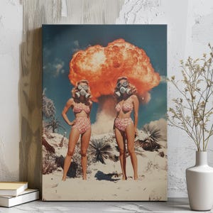Könnte beinhalten: Vintage-Druck mit zwei Frauen in passenden rosa geblümten Bikinis und Gasmasken, vor einer Wüstenlandschaft mit einer großen orangefarbenen Atompilzwolke. Das Kunstwerk hat ein Retro- und postapokalyptisches Thema mit einer surrealen Ästhetik.