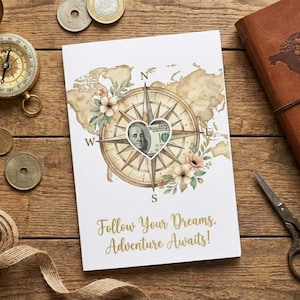 May include: A white card with a compass rose design, a map, and the text "Follow Your Dreams. Adventure Awaits!" is surrounded by coins, a compass, a journal, scissors, and twine on a wooden surface.