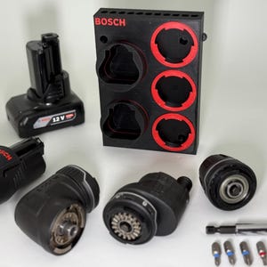 Puede incluir: Colección de accesorios negros para herramientas eléctricas Bosch, que incluyen baterías, accesorios para taladros y un estante de almacenamiento. El estante es negro con detalles rojos y el logotipo de Bosch. Baterías de 12V y 3,0 Ah.