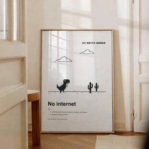 Op de afbeelding: Een ingelijste print met een minimalistisch ontwerp. Het toont een gepixeld dinosaurus, wolken en cactussen op een witte achtergrond. De tekst "No internet" wordt hieronder weergegeven, samen met tips voor probleemoplossing. De lijst is licht van kleur.