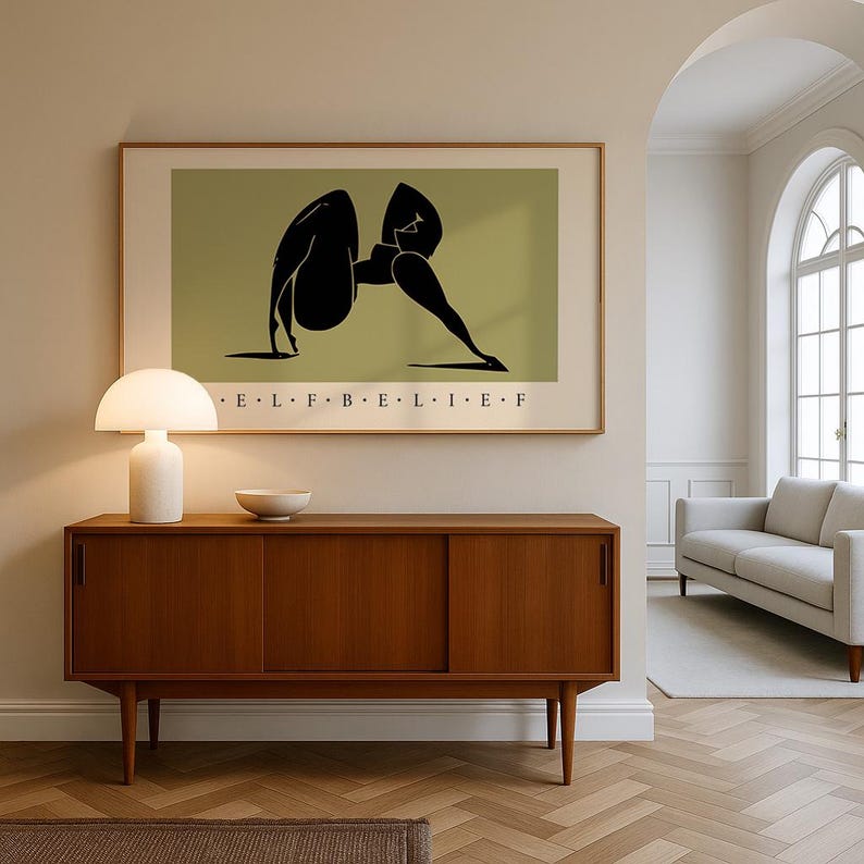 May include: A framed horizontal wall art print featuring a black abstract silhouette of a figure in a yoga pose against an olive green background. The text E L F B E L I E F is printed in black capital letters centered below the illustration.
