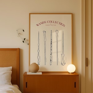 Puede incluir: Una impresión enmarcada con fondo blanco y dibujos en línea negra de cinco varitas. El título de la impresión es "Wands Collection of Harry Potter" en texto rojo.