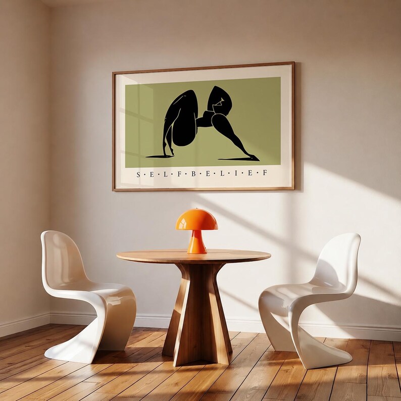 May include: A framed horizontal wall art print featuring a stylized black silhouette of a figure in a yoga pose against a muted olive green background, with the text "S E L F B E L I E F" printed in black capital letters centered below the illustration.