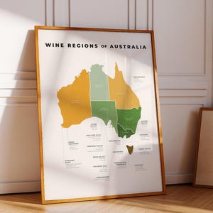 Puede incluir: Un póster enmarcado titulado "Wine Regions of Australia". El mapa de Australia está coloreado en tonos verdes y dorados, con cada región vinícola etiquetada. El marco es de color marrón claro.