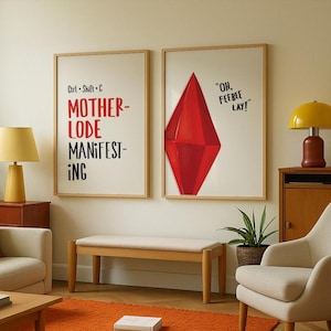 May include: Two framed art prints with wooden frames. One print reads "Ctrl + Shift + C, MOTHER-LODE, MANIFEST-ING" in red and black. The other features a red diamond shape and the text "OH, FEEBEE LAY!" on a white background.