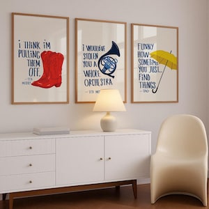 May include: Three framed prints with quotes from the TV show "How I Met Your Mother". The first print features a red cowboy boot and the quote "I think I'm pulling them off." The second print features a blue french horn and the quote "I would've stolen you a whole orchestra." The third print features a yellow umbrella and the quote "Funny how sometimes you just... find things."